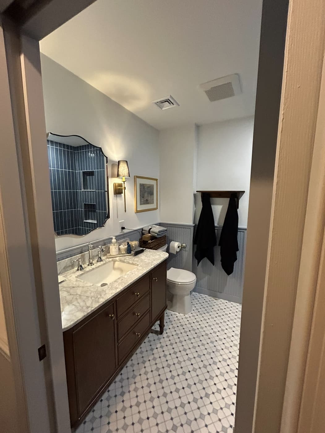 Bathroom vanity with a marble top over a mosaic tile floor