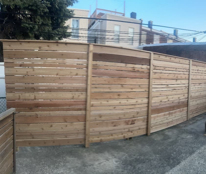 Cedar horizontal-slat privacy fence enclosing a backyard patio