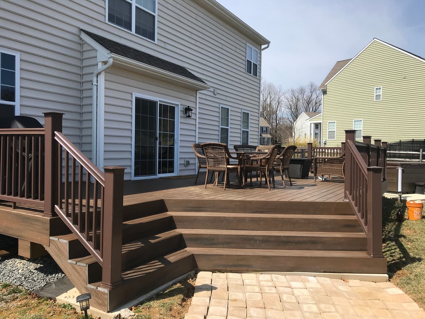 Composite deck with wide steps down to a paver landing