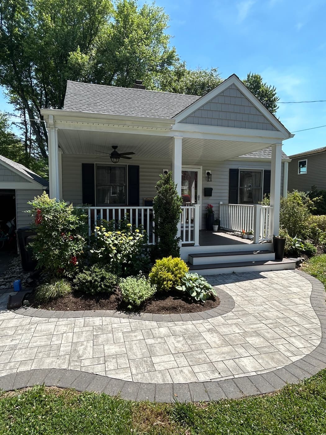 Curved decorative paver walkway leading to a front porch