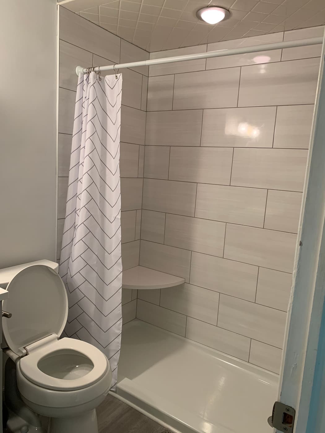 Tub and shower with a light gray tile surround