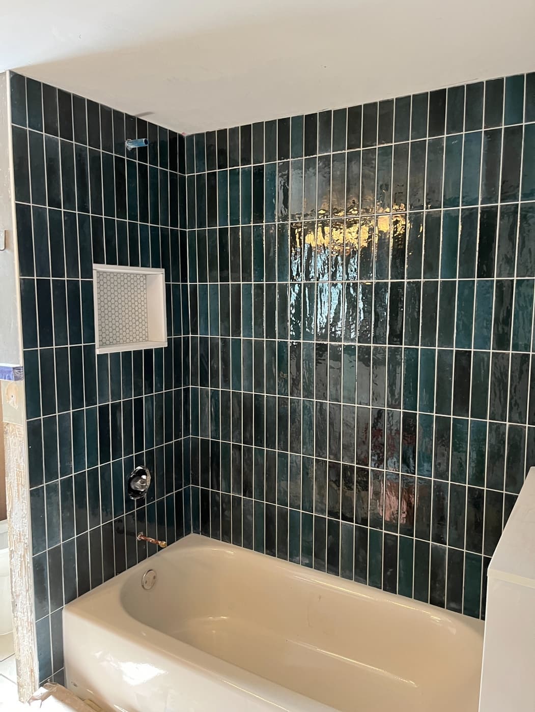 Tub and shower with deep green vertical stacked tile